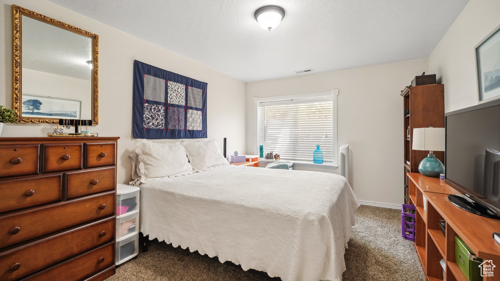 Bedroom featuring dark colored carpet and baseboards