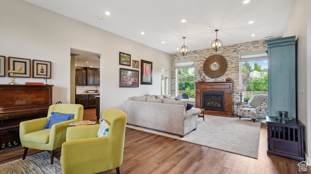 Living room featuring plenty of natural light, recessed lighting, wood finished floors, and a glass covered fireplace