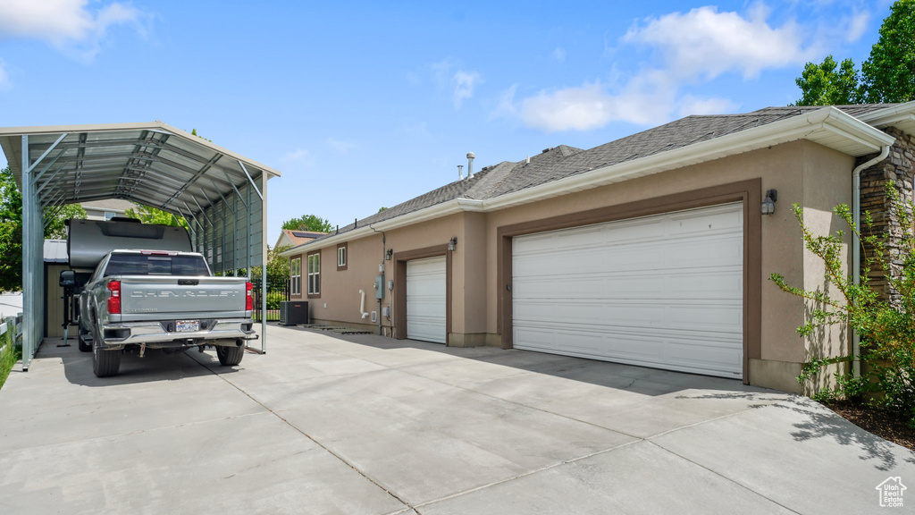 View of side of property with driveway, stucco siding, and an attached garage