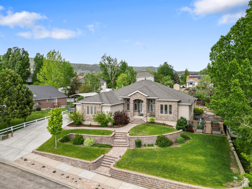 View of front facade with stucco siding, concrete driveway, and roof with shingles