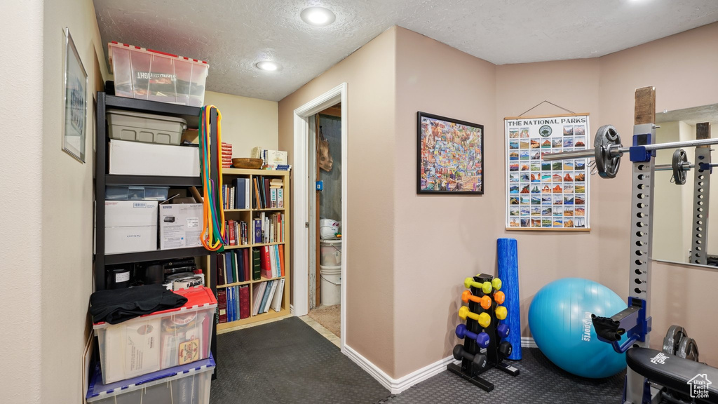 Workout area featuring carpet flooring, baseboards, a textured ceiling, and recessed lighting