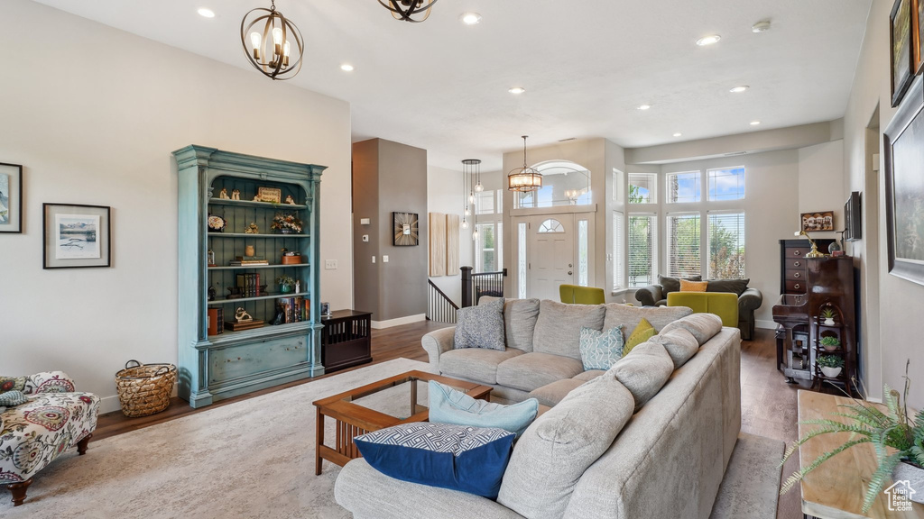 Living area with a chandelier, recessed lighting, baseboards, and wood finished floors