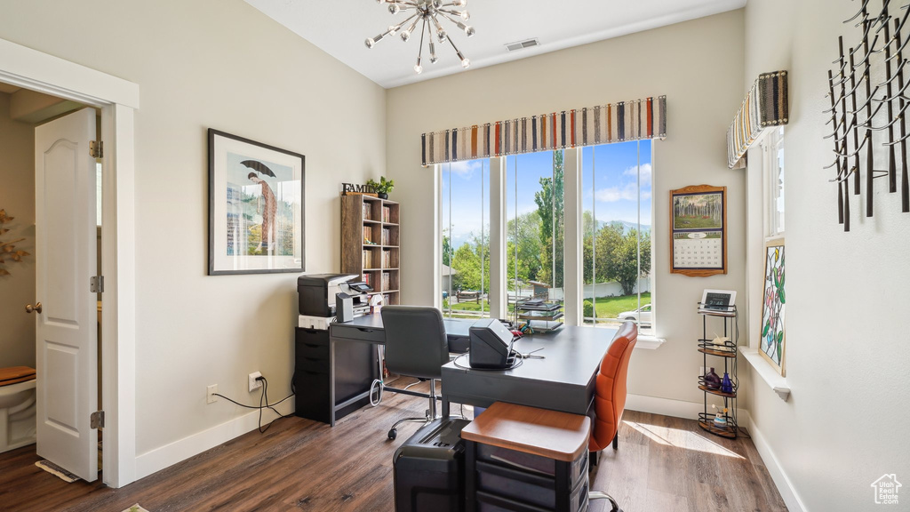 Home office with a chandelier, dark wood finished floors, and plenty of natural light