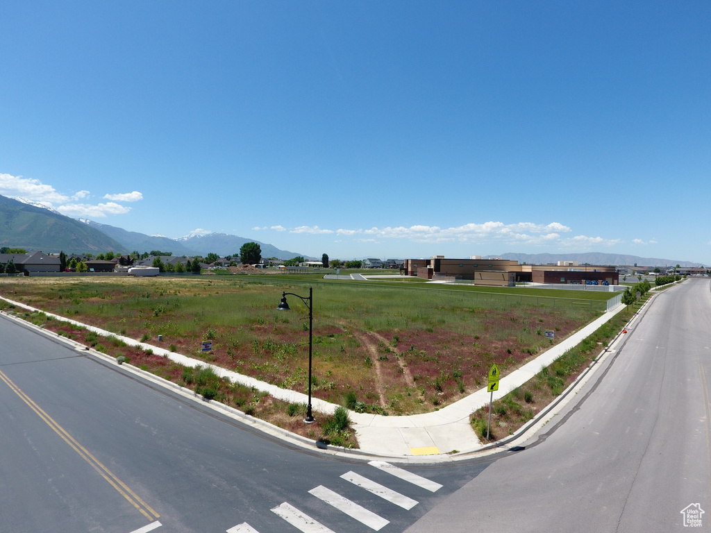 View of asphalt road featuring a mountain view and curbs