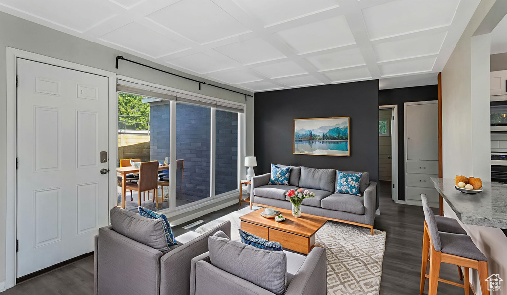 Living area featuring dark wood-style flooring, coffered ceiling, and baseboards