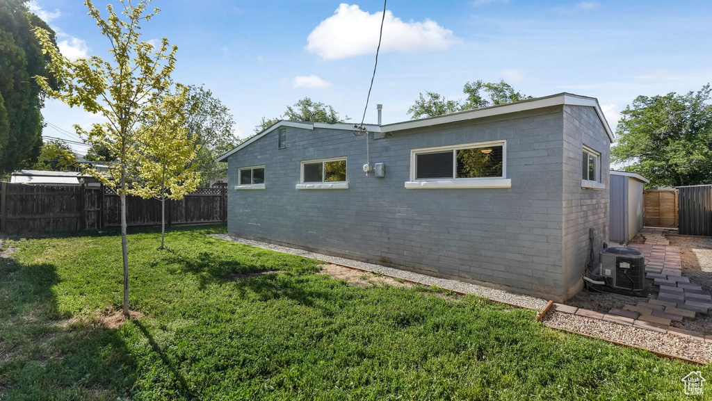 View of side of home featuring central air condition unit and brick siding