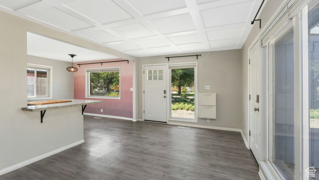 Unfurnished living room with baseboards, dark wood finished floors, and coffered ceiling