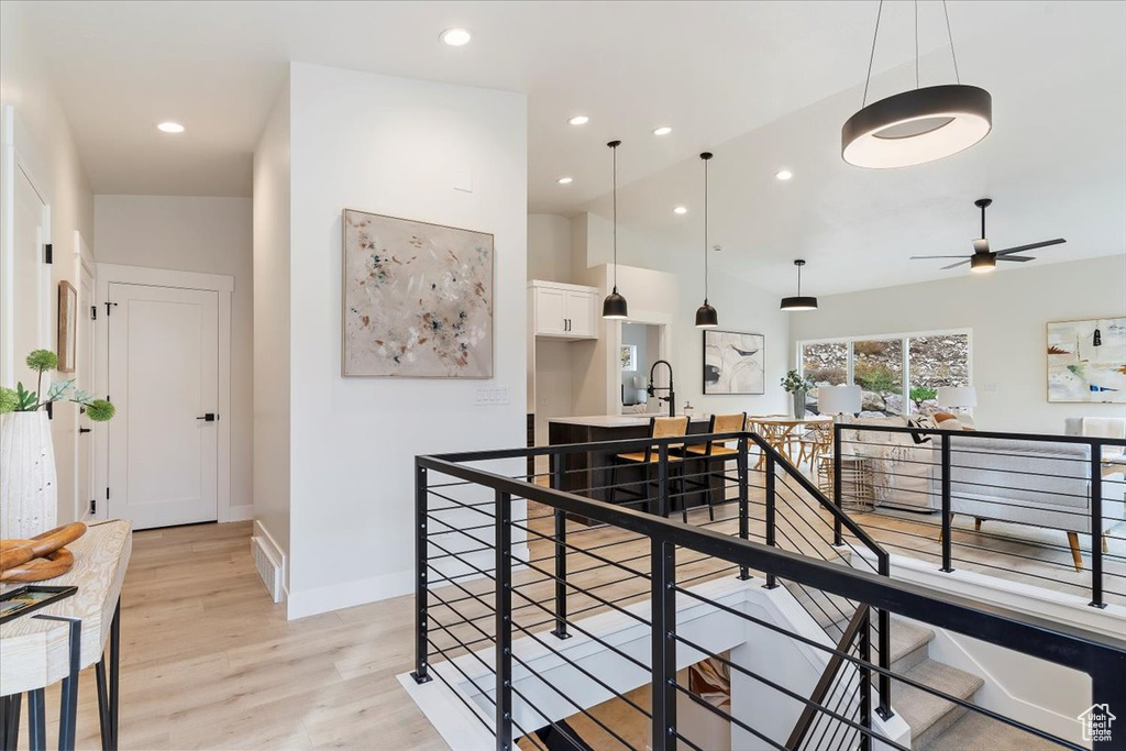 Hall featuring an upstairs landing, light wood-style floors, baseboards, and recessed lighting