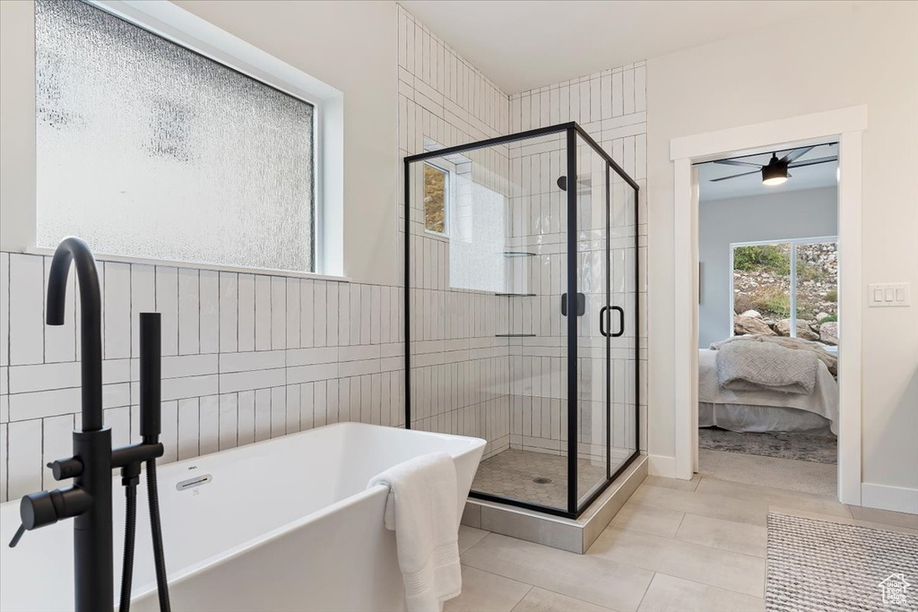 Ensuite bathroom with a soaking tub, a shower stall, and tile patterned flooring