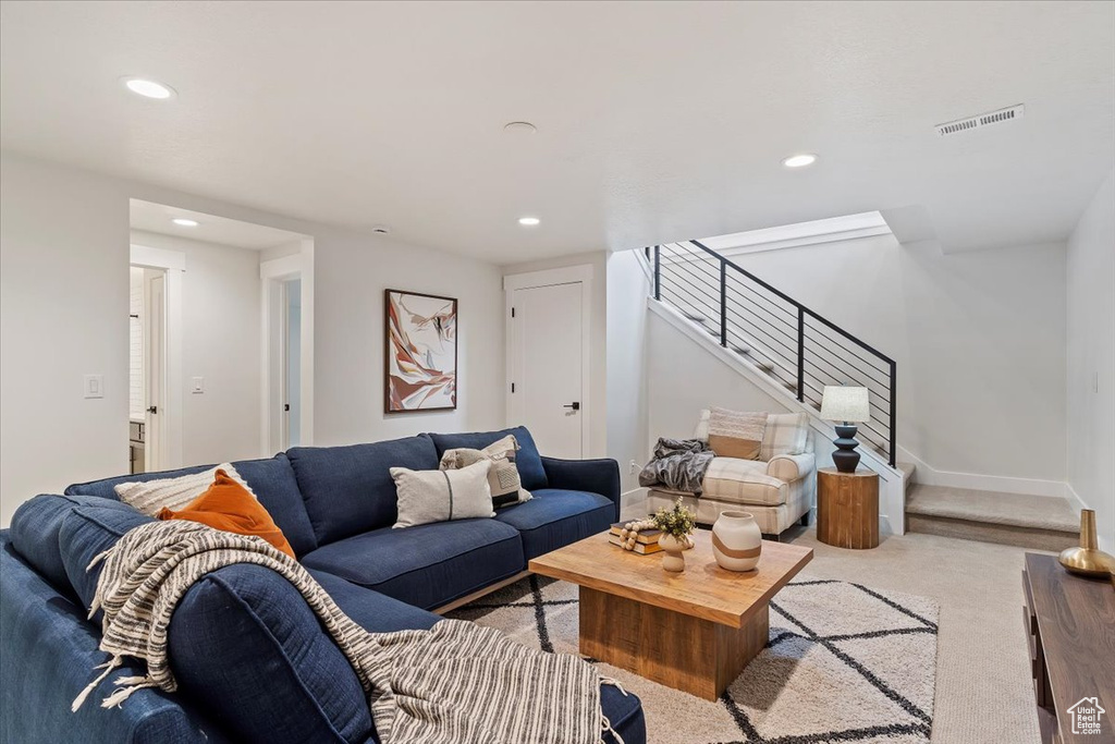 Carpeted living area featuring stairway, recessed lighting, and baseboards