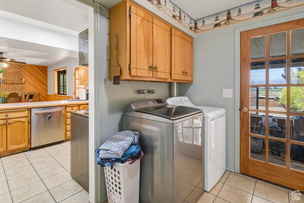 Laundry area featuring cabinet space, independent washer and dryer, light tile patterned flooring, and a ceiling fan