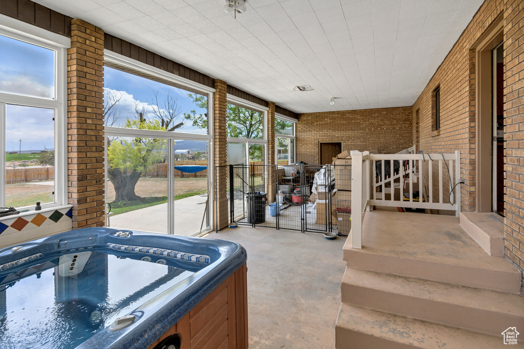 Sunroom with a jacuzzi and plenty of natural light