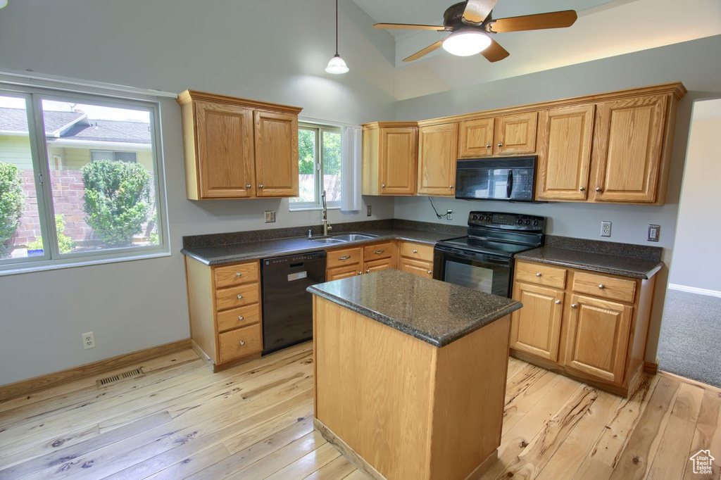 Kitchen featuring black appliances, ceiling fan, a sink, lofted ceiling, and light wood finished floors