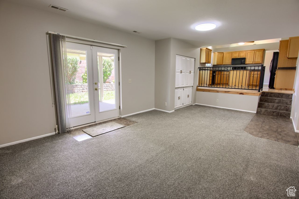 Unfurnished living room with carpet flooring, french doors, and baseboards