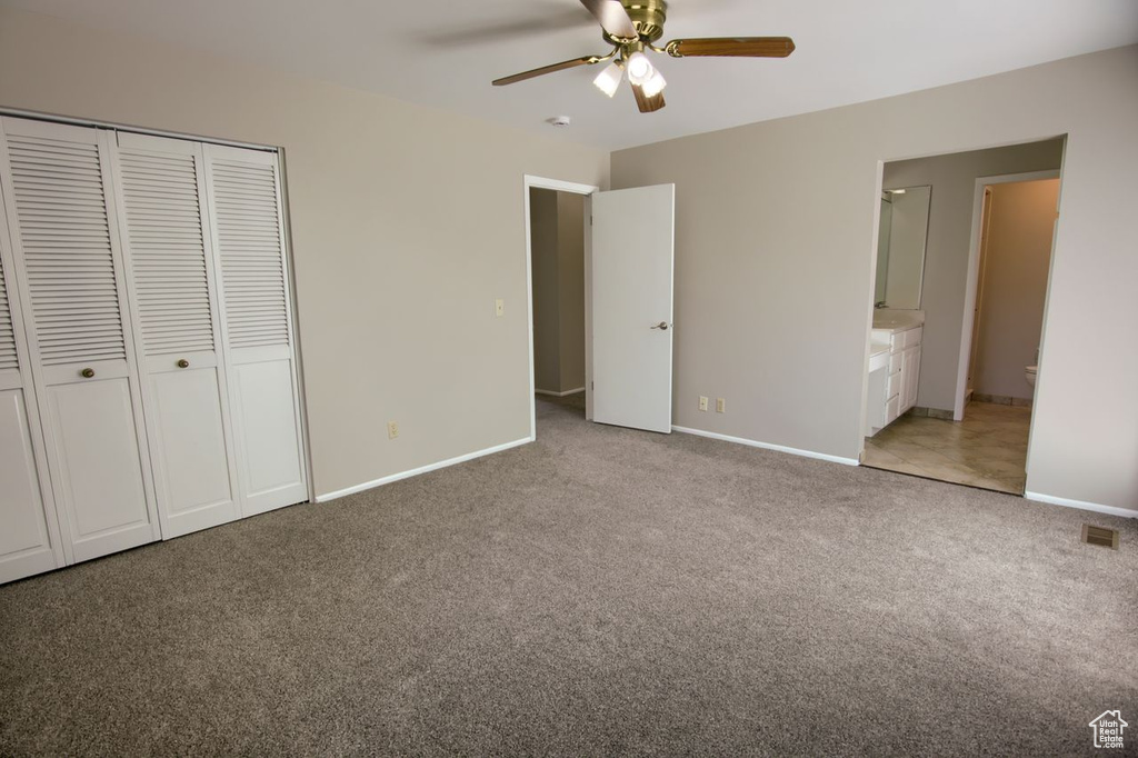 Unfurnished bedroom featuring light carpet, baseboards, a closet, and connected bathroom