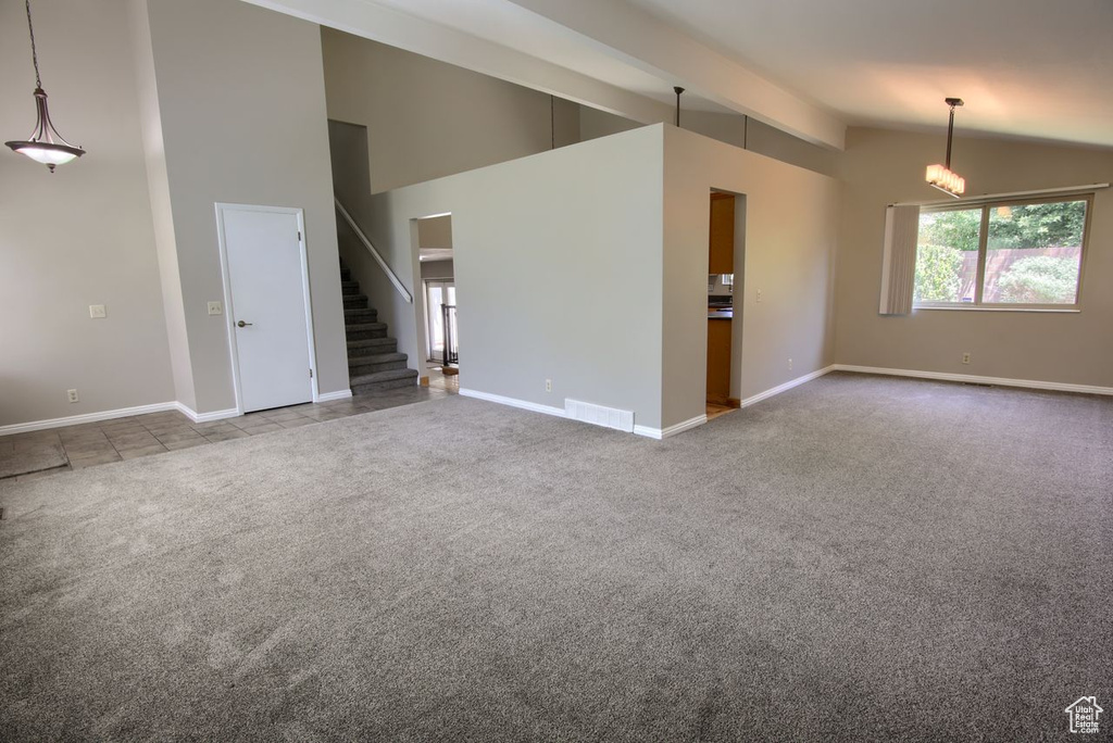 Unfurnished living room with carpet, stairs, and baseboards
