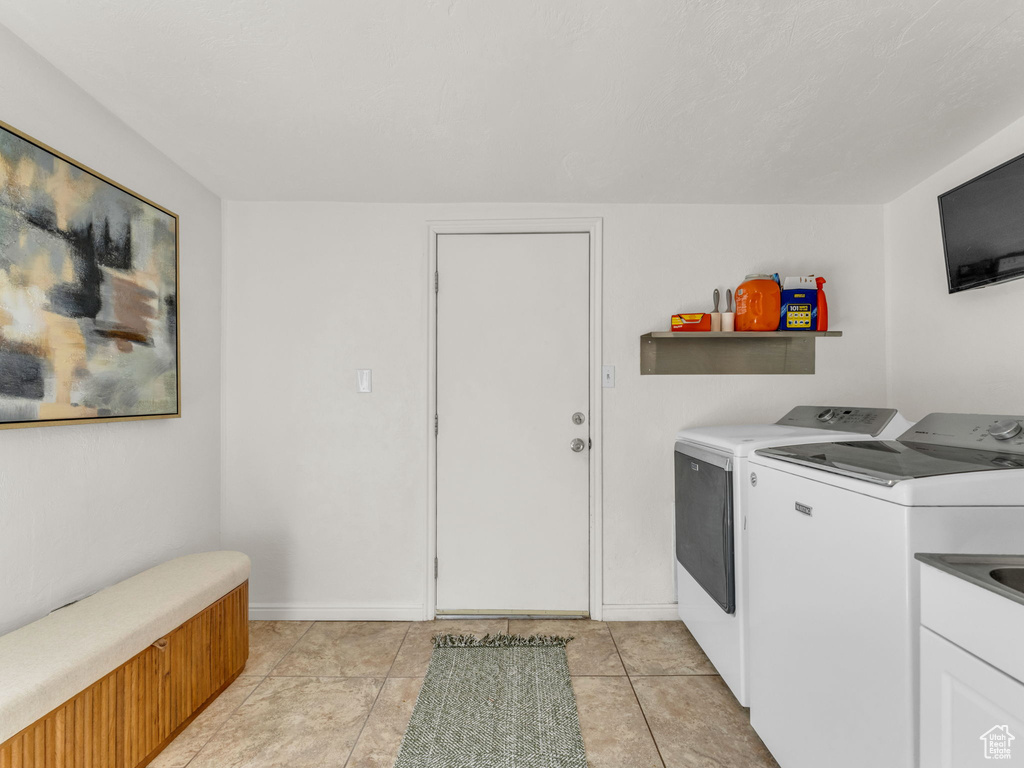 Laundry room with washer and clothes dryer and baseboards