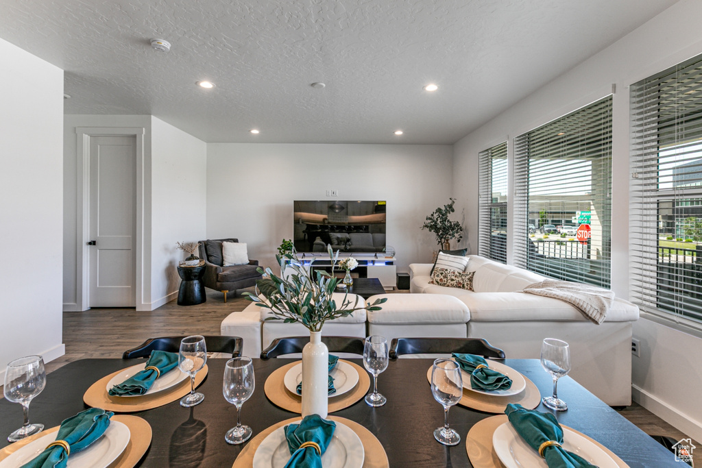 Living area with wood finished floors, baseboards, recessed lighting, and a textured ceiling