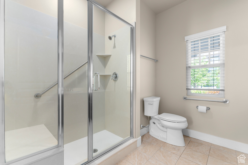 Full bathroom with baseboards, toilet, a shower stall, and tile patterned flooring