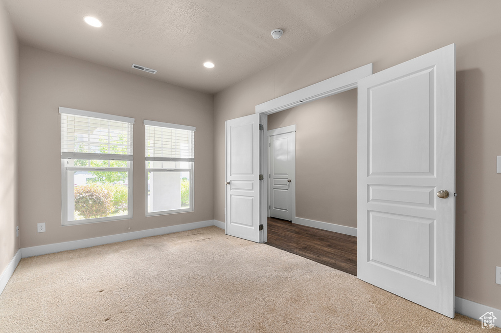 Unfurnished bedroom with carpet, baseboards, and recessed lighting