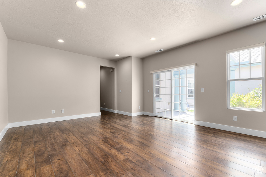 Spare room featuring recessed lighting, dark wood-style floors, and baseboards
