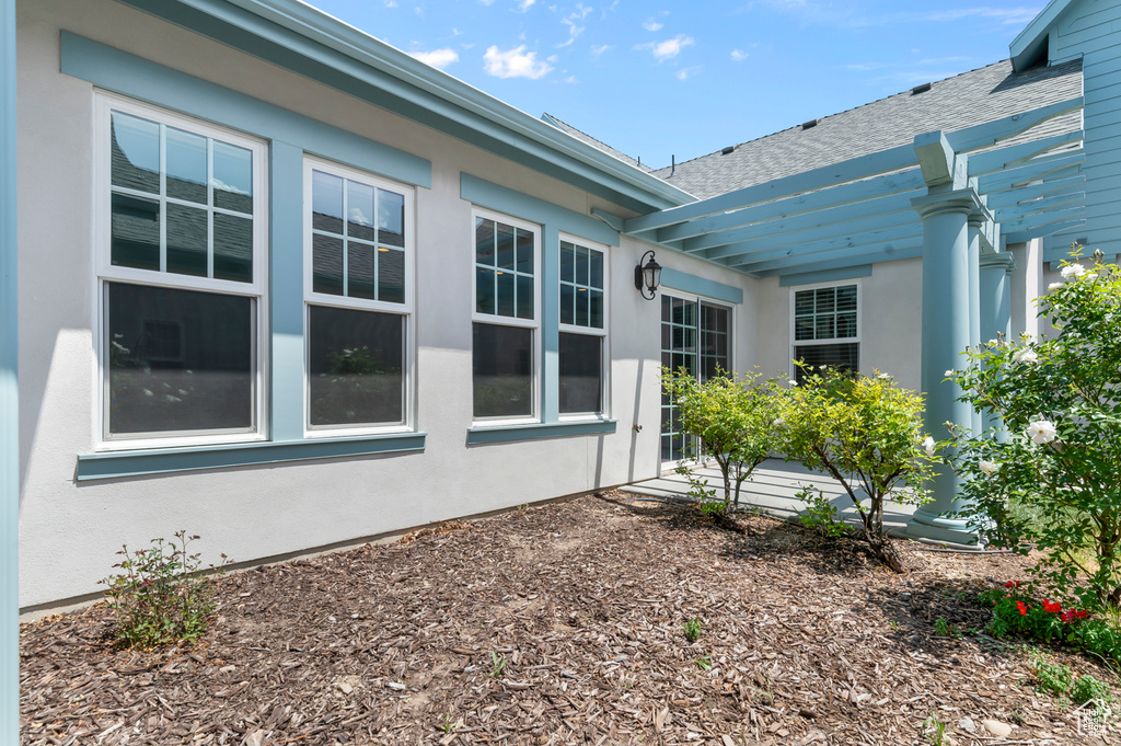 View of property exterior featuring roof with shingles and stucco siding