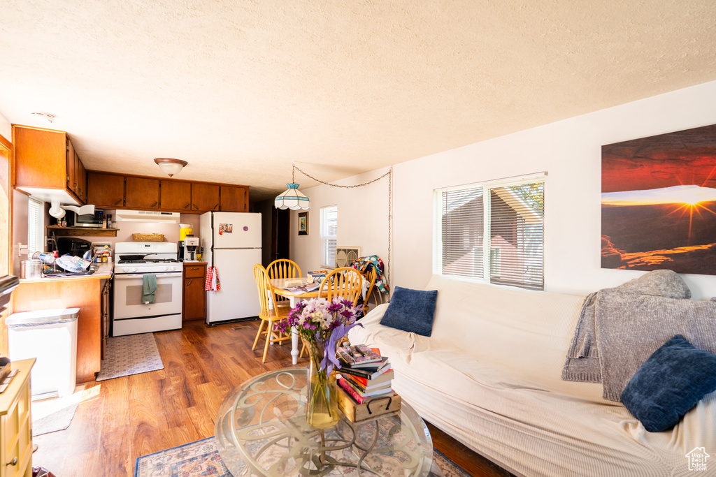 Living area featuring light wood-type flooring and a textured ceiling