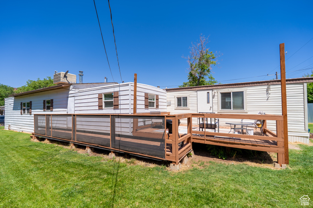 Back of house featuring a yard and a deck
