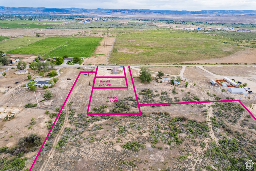 Aerial view of sparsely populated area featuring a mountainous background and property parcel outlined