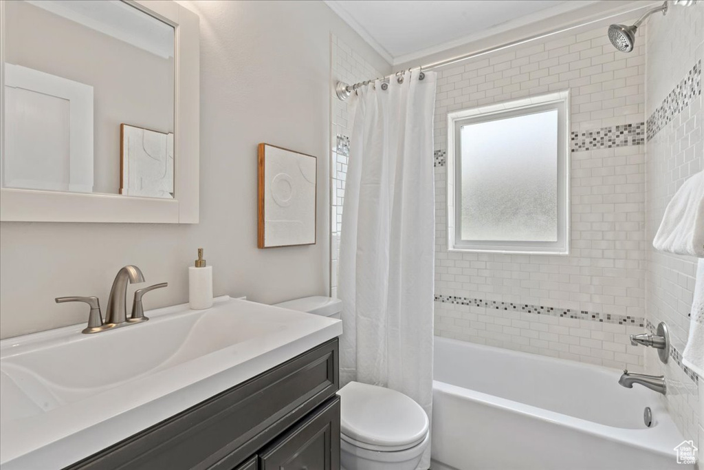 Full bathroom with toilet, vanity, and shower / bath combo