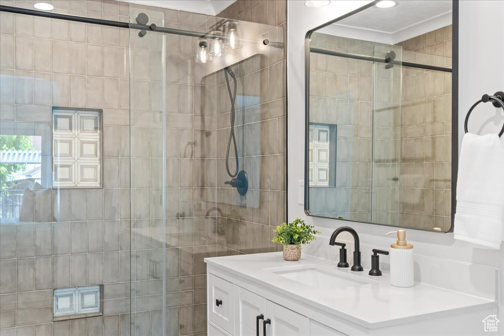 Bathroom featuring vanity and a tile shower