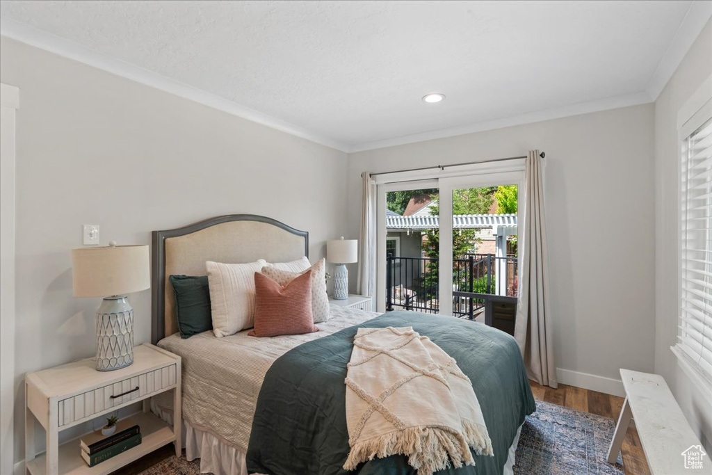 Bedroom with access to outside, baseboards, wood finished floors, recessed lighting, and crown molding