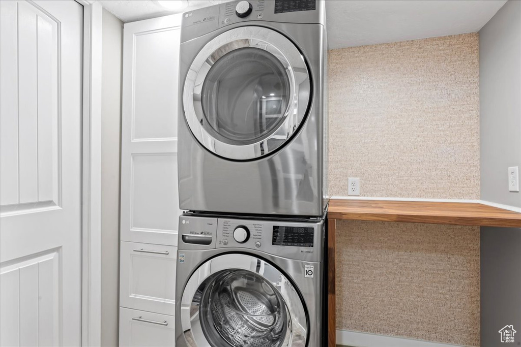 Laundry room featuring estacked washer and dryer and cabinet space