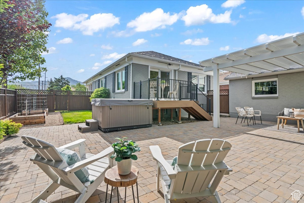 Fenced backyard featuring a hot tub, a patio area, and a pergola