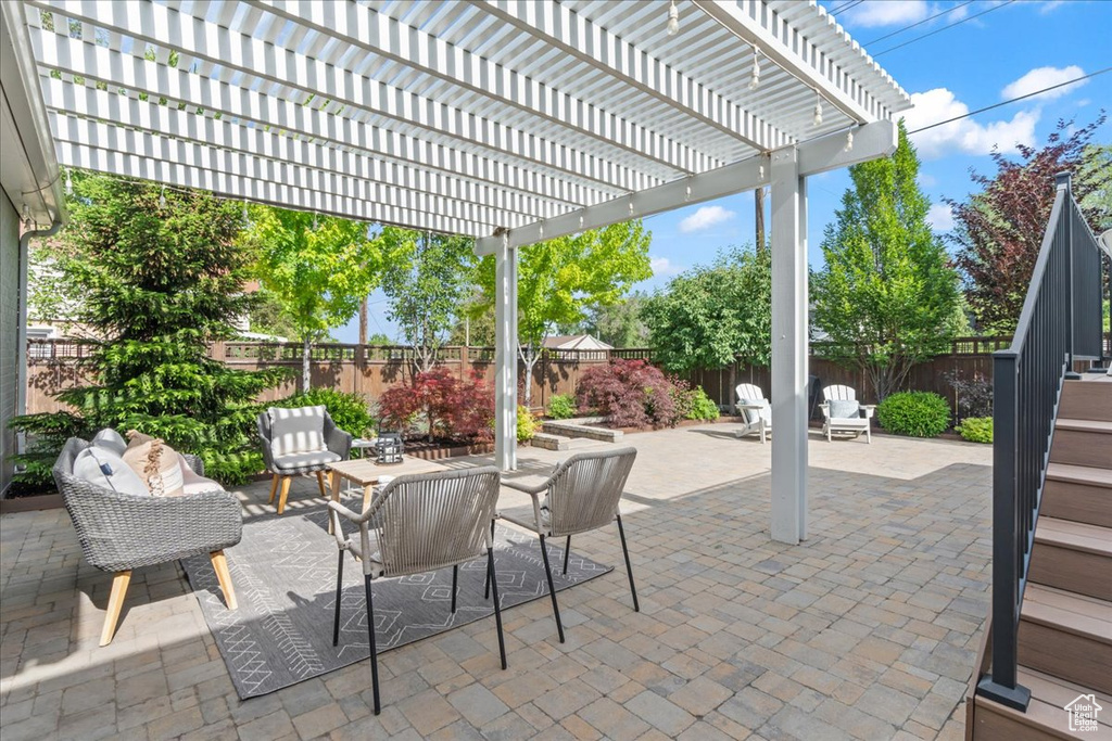 Fenced backyard with a patio area, a pergola, and outdoor dining area