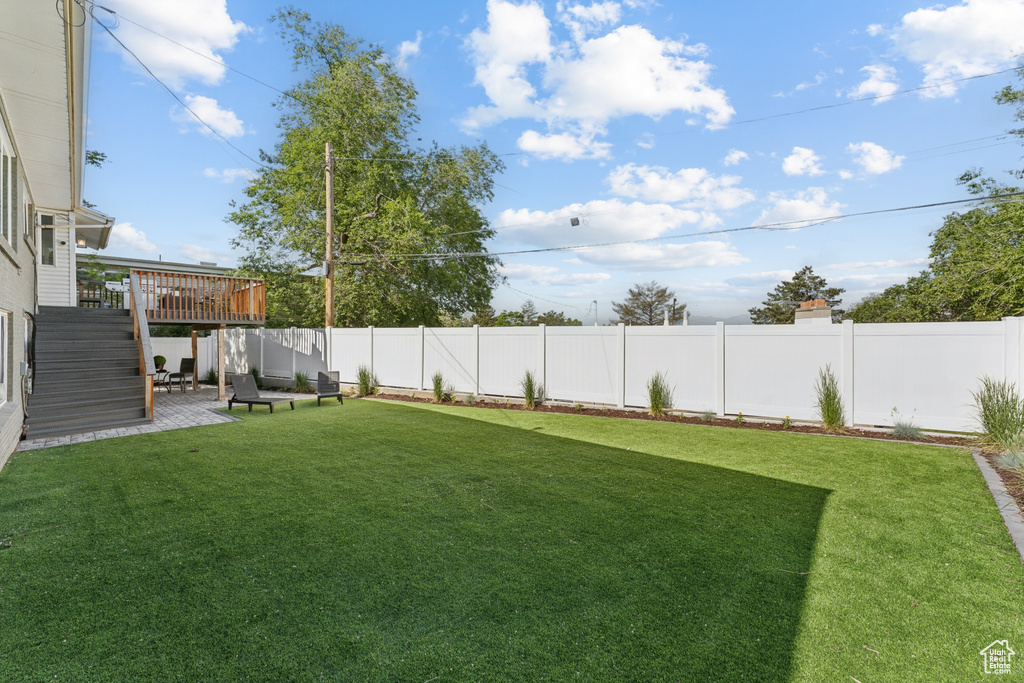 View of yard featuring a deck and a patio area