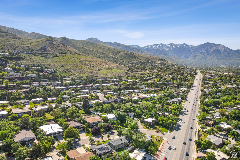 Aerial view of residential area featuring a mountain backdrop and a highway