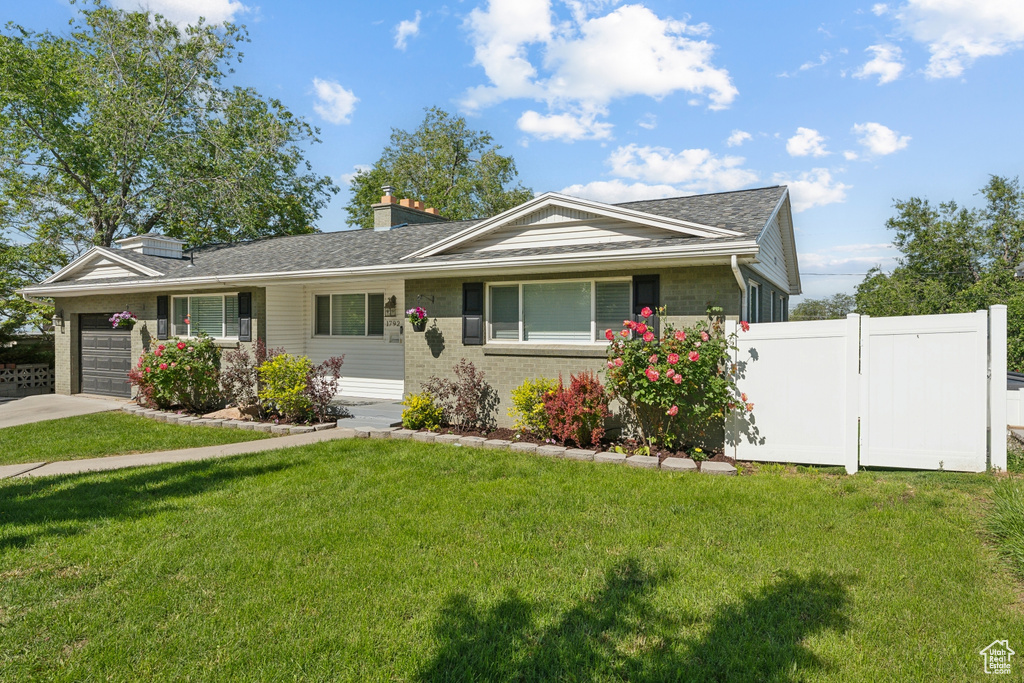Single story home featuring a garage, a chimney, concrete driveway, and brick siding