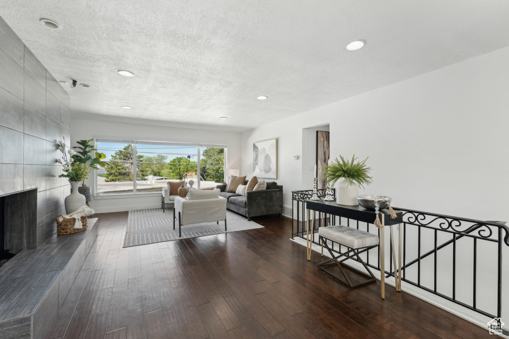 Living area featuring hardwood / wood-style flooring, a textured ceiling, recessed lighting, and baseboards