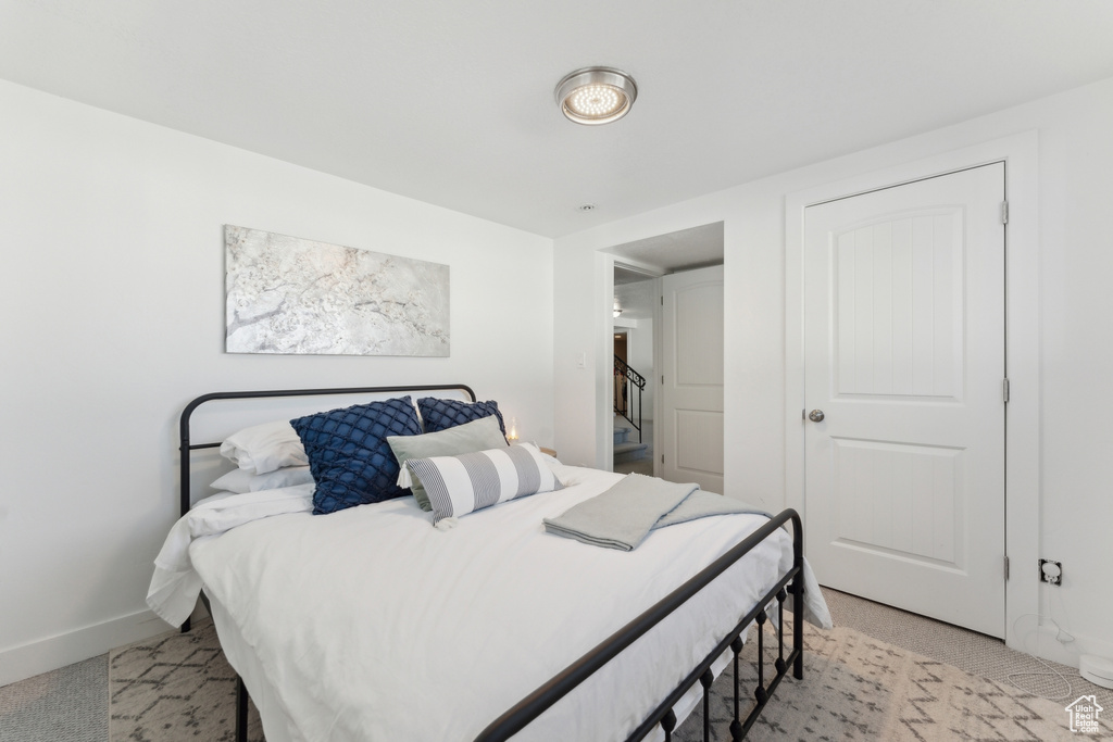 Bedroom with baseboards and light carpet