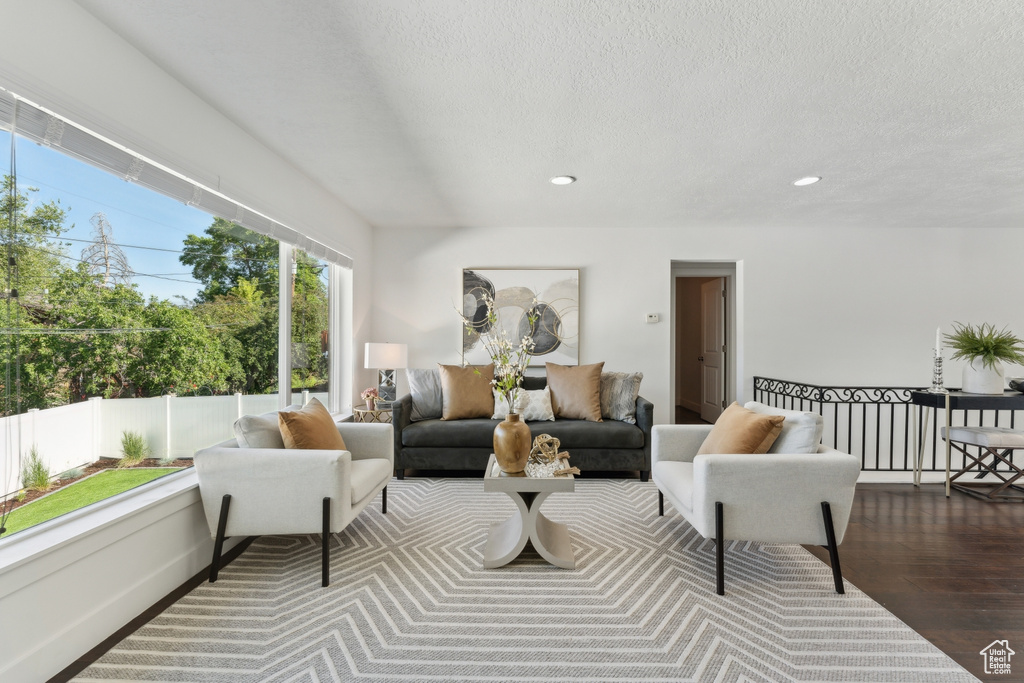 Living area with wood finished floors, recessed lighting, and a textured ceiling
