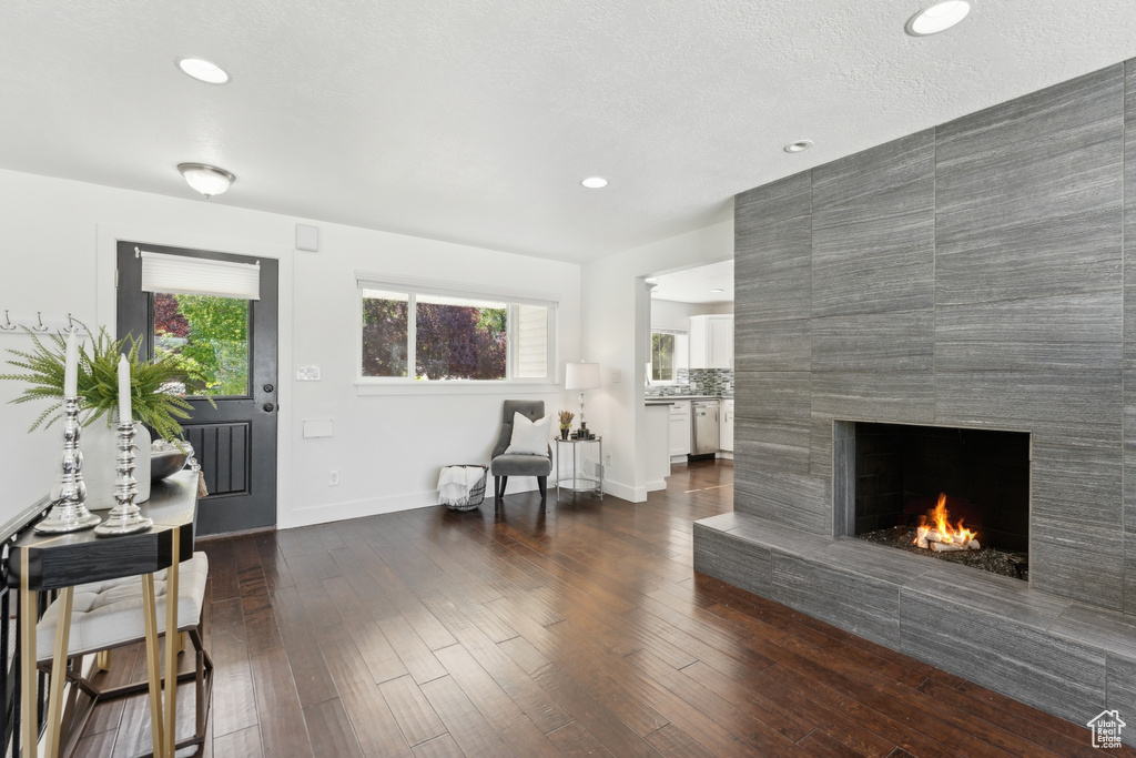 Sitting room with healthy amount of natural light, a fireplace, dark wood-type flooring, recessed lighting, and baseboards