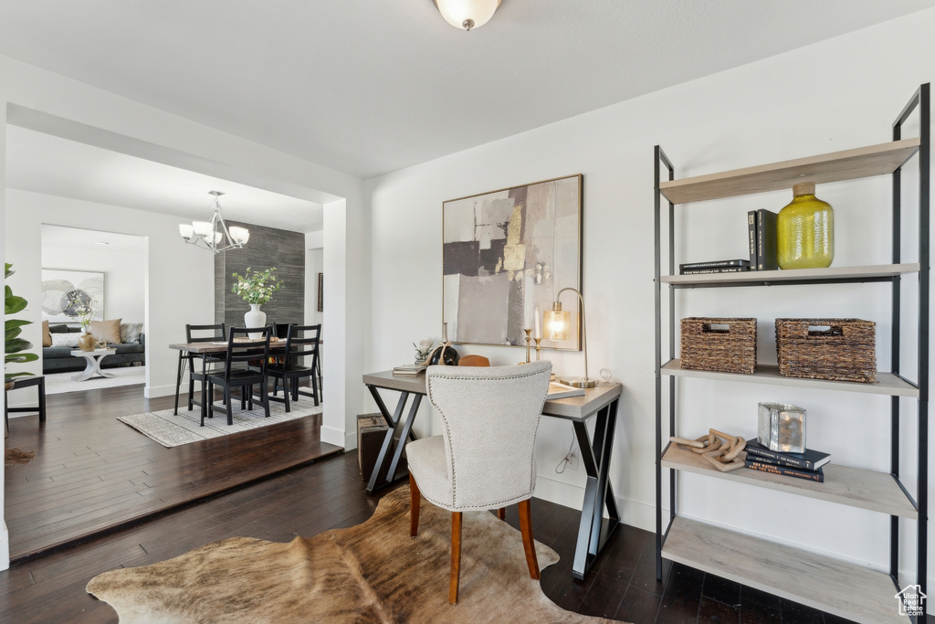 Home office featuring a chandelier, hardwood / wood-style floors, and baseboards