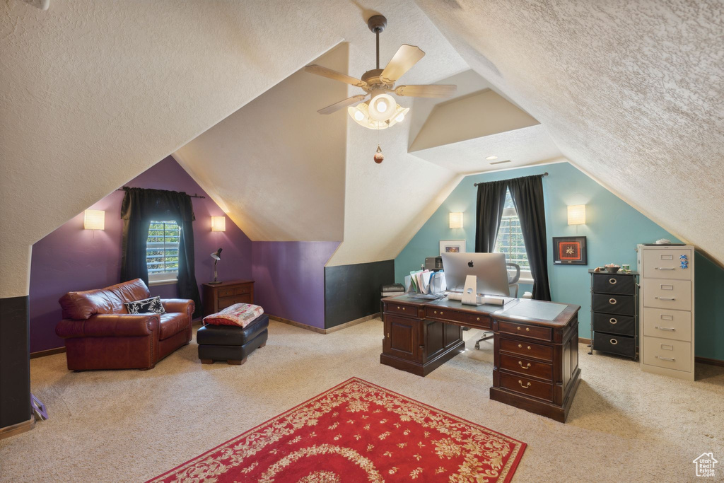 Office area with a textured ceiling, light colored carpet, plenty of natural light, lofted ceiling, and ceiling fan