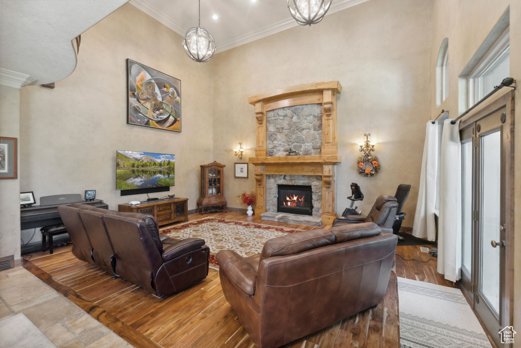 Living area featuring ornamental molding, healthy amount of natural light, a fireplace, a high ceiling, and baseboards