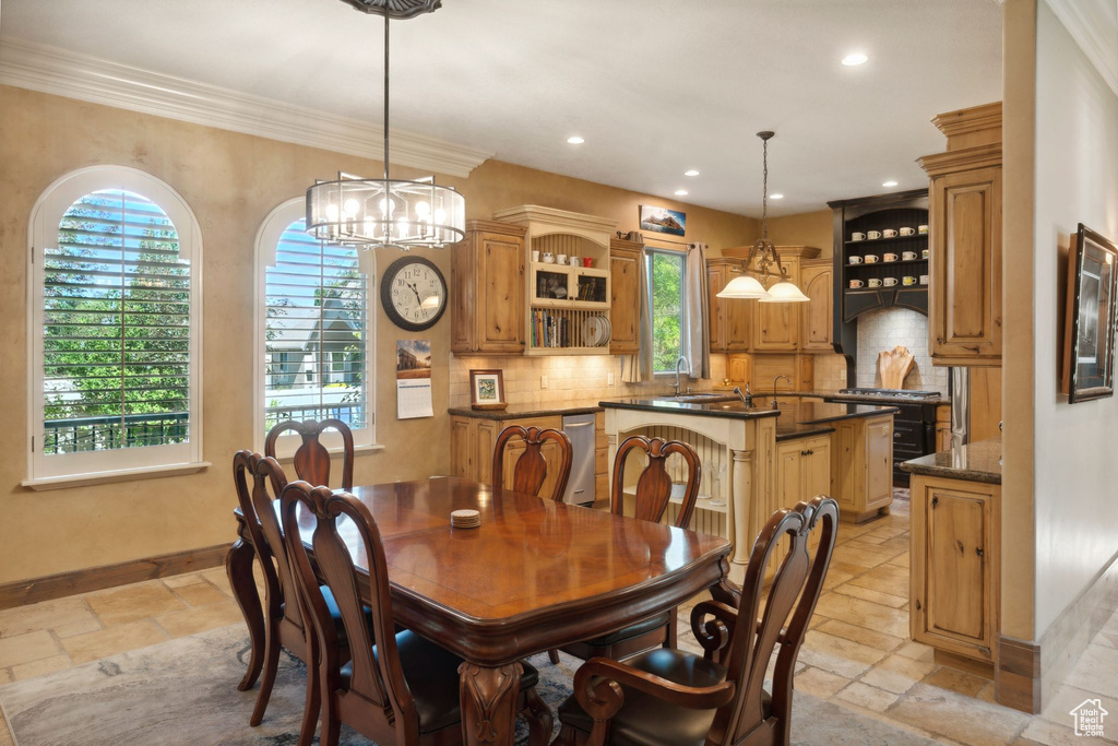 Dining area featuring stone tile floors, a chandelier, recessed lighting, baseboards, and ornamental molding