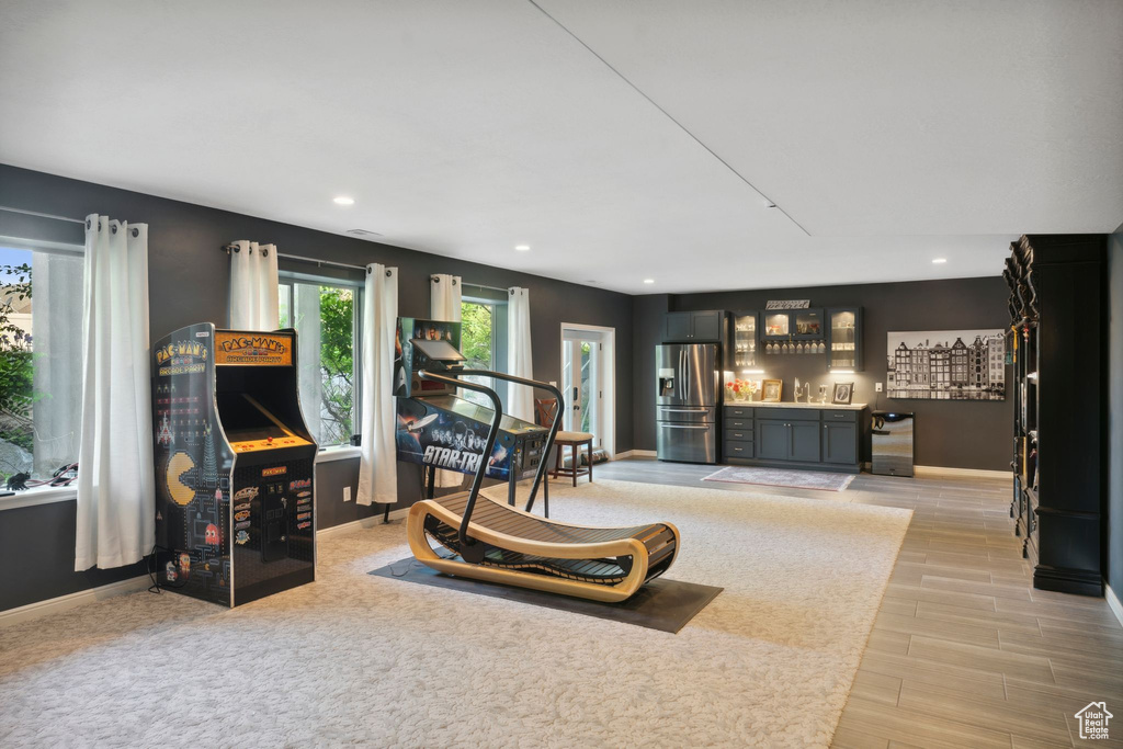 Living room featuring a bar, baseboards, recessed lighting, and light wood-type flooring