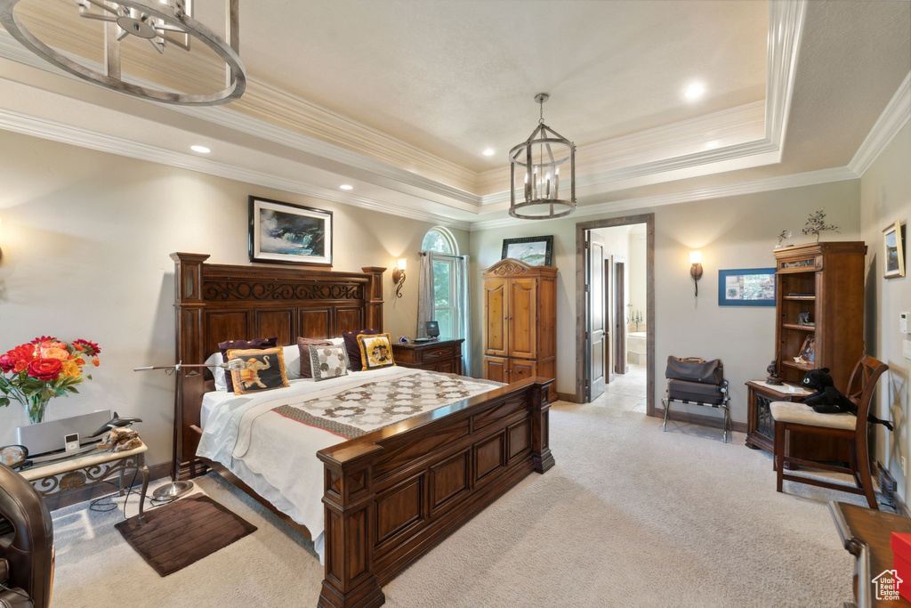 Bedroom featuring light carpet, a tray ceiling, a chandelier, baseboards, and crown molding