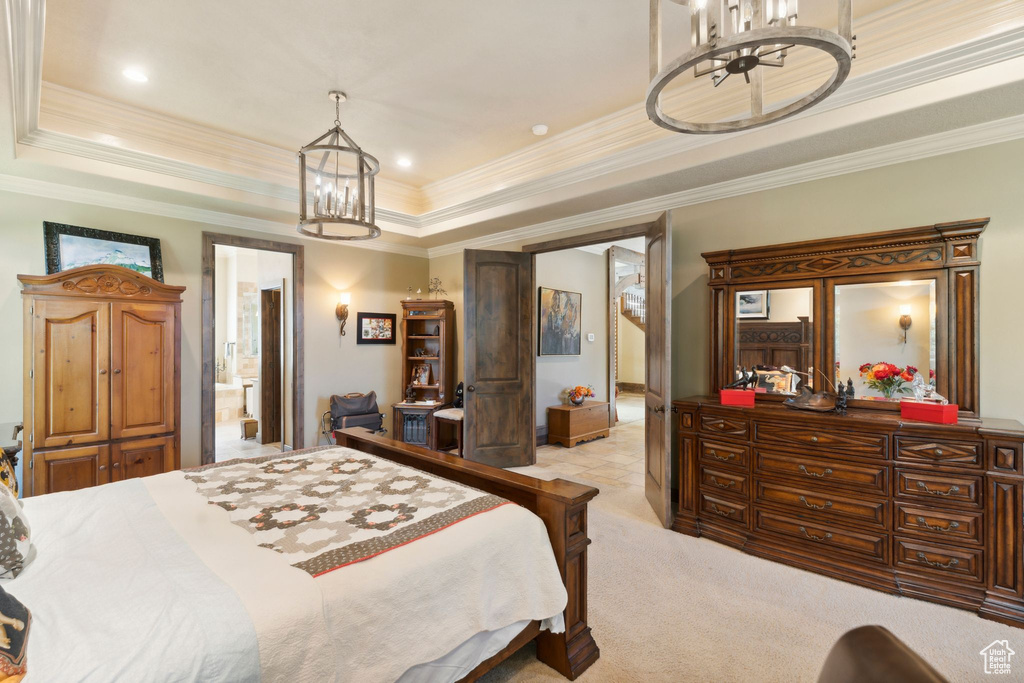 Bedroom featuring a chandelier, a raised ceiling, ornamental molding, light carpet, and baseboards
