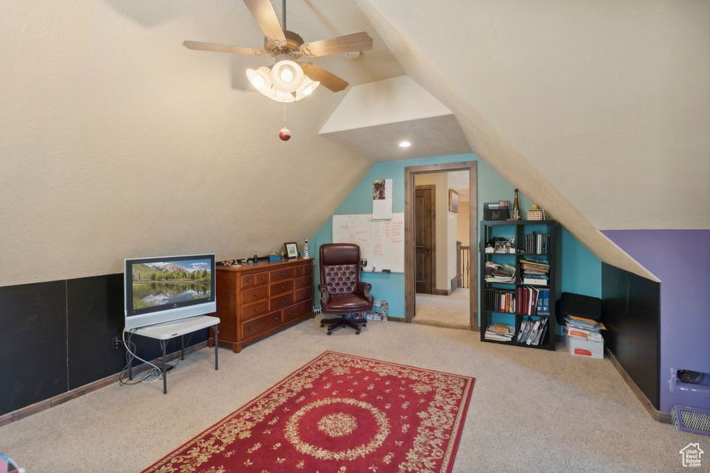 Carpeted office space featuring lofted ceiling and ceiling fan